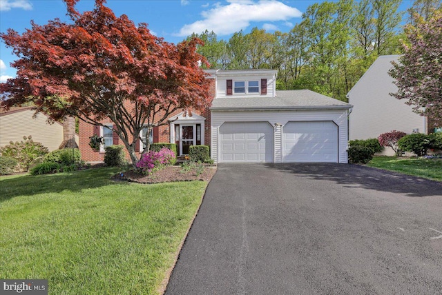 view of front of property with an attached garage, driveway, and a front lawn