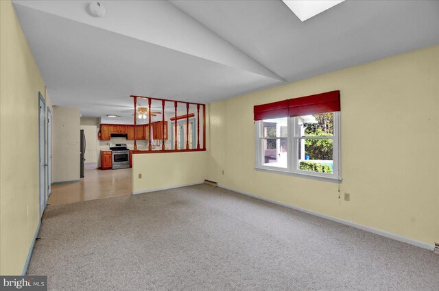 unfurnished living room featuring baseboards, light carpet, vaulted ceiling, and visible vents