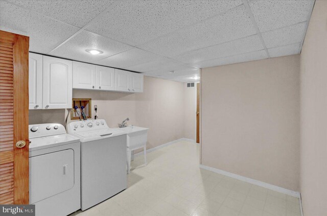 laundry room featuring visible vents, baseboards, light floors, washing machine and clothes dryer, and cabinet space