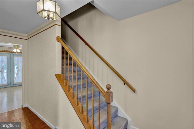 stairs featuring baseboards, ceiling fan, and wood finished floors