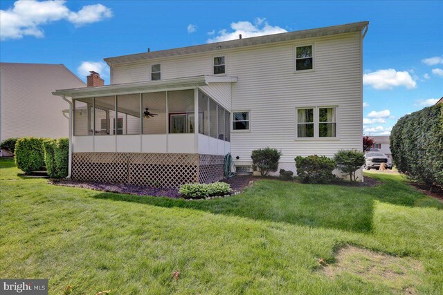 rear view of house featuring a sunroom, ceiling fan, and a lawn