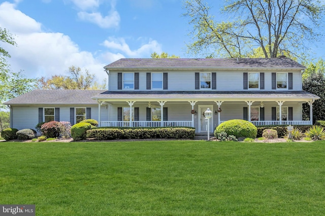 view of front of home with covered porch and a front lawn
