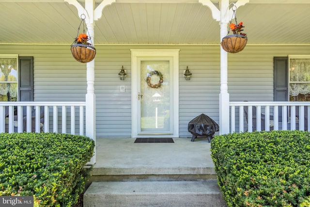 view of exterior entry featuring covered porch