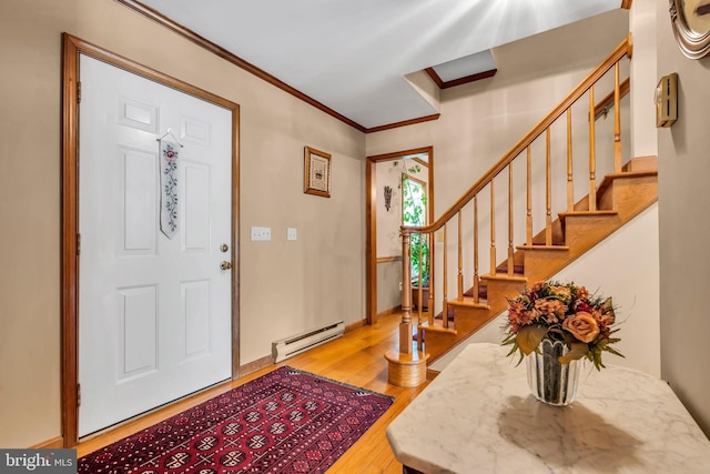 foyer with crown molding, baseboard heating, stairs, and wood finished floors
