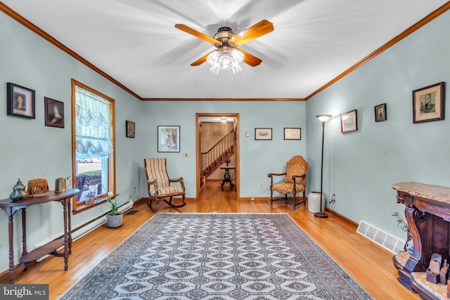 living area featuring crown molding, stairway, ceiling fan, and hardwood / wood-style flooring
