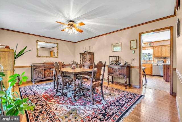 dining room featuring ceiling fan, ornamental molding, and light wood-style flooring