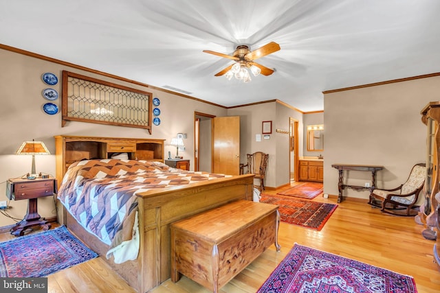 bedroom with baseboards, ornamental molding, light wood finished floors, and visible vents