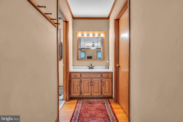 bathroom with vanity, crown molding, and wood finished floors