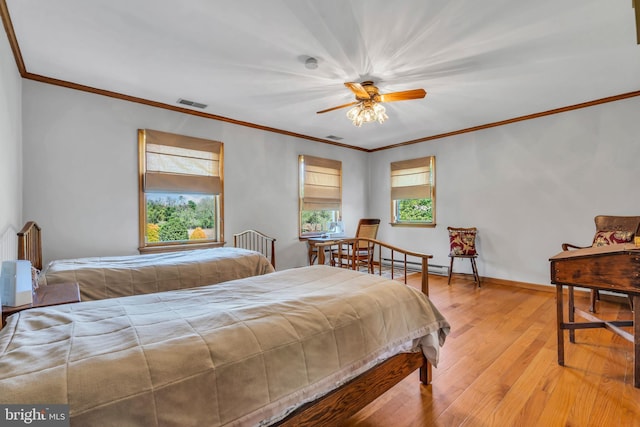 bedroom featuring visible vents, multiple windows, ornamental molding, and light wood finished floors