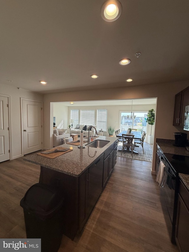 kitchen with a sink, black electric range oven, stone countertops, recessed lighting, and dark wood-style flooring