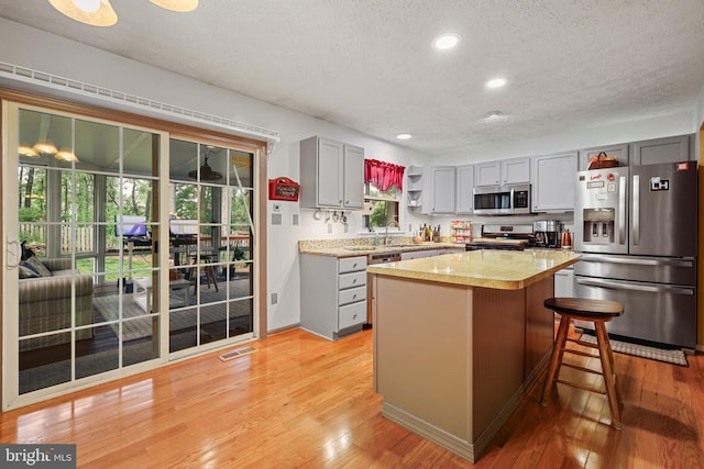 7815 Shallowbrook Ct, Severn, MD 21144 - kitchen with a textured ceiling, visible vents, light countertops, appliances with stainless steel finishes, and gray cabinets