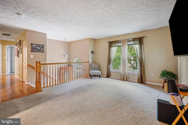 7815 Shallowbrook Ct, Severn, MD 21144 - sitting room with a textured ceiling, baseboards, visible vents, an upstairs landing, and carpet floors