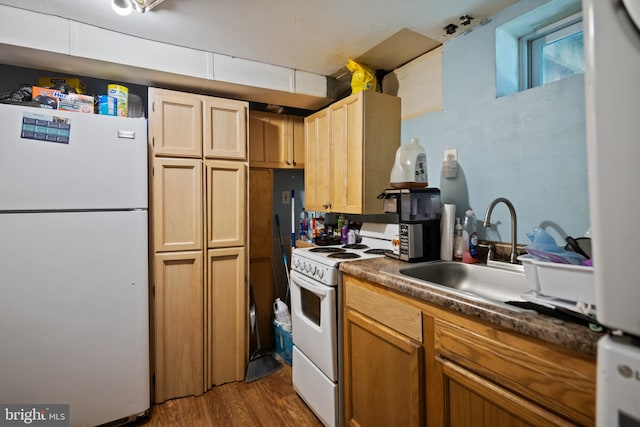 kitchen with white appliances, dark wood-style floors, and a sink
