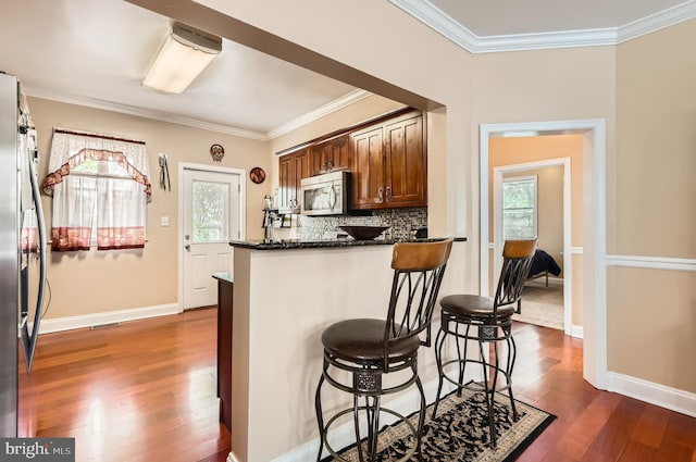 3717 Nortonia Rd, Baltimore, MD 21216 - kitchen featuring stainless steel appliances, ornamental molding, dark wood-style floors, and healthy amount of natural light