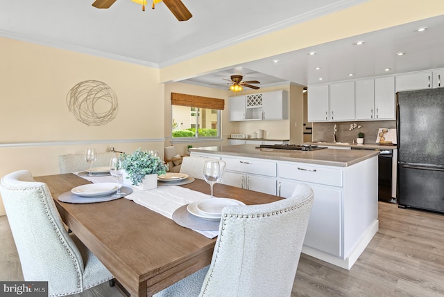 dining area featuring ceiling fan, ornamental molding, and light wood-type flooring
