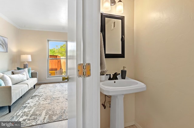 bathroom featuring baseboards, ornamental molding, wood finished floors, and visible vents