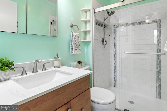 bathroom featuring vanity, toilet, and a stall shower