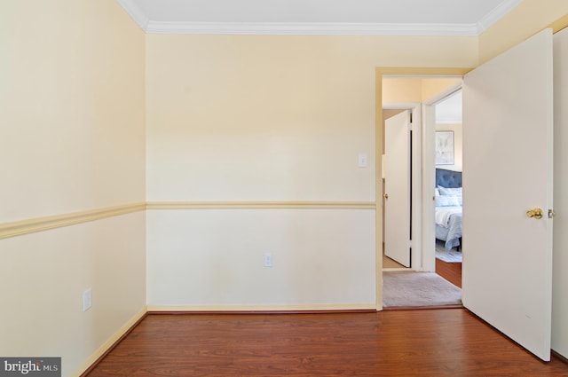unfurnished room with ornamental molding and wood finished floors