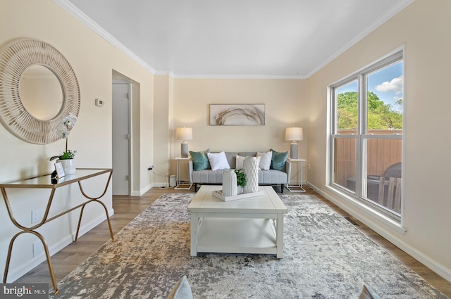 living room with crown molding, baseboards, and wood finished floors