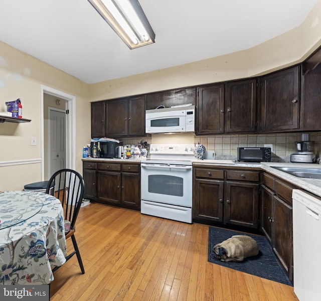 1806 Cranberry Ln, Reston, VA 20191 - kitchen featuring white appliances, dark brown cabinetry, light wood-type flooring, and decorative backsplash