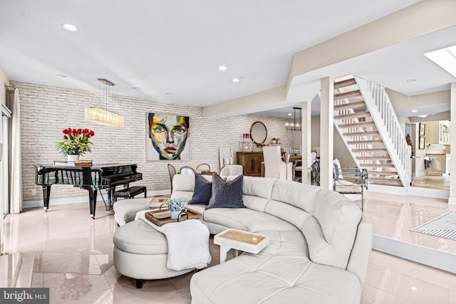 living area with stairway, a skylight, recessed lighting, and brick wall