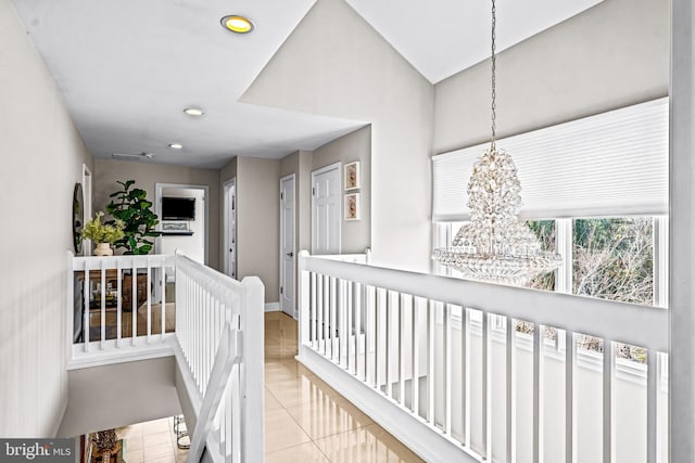 hallway with tile patterned floors, baseboards, an upstairs landing, an inviting chandelier, and recessed lighting
