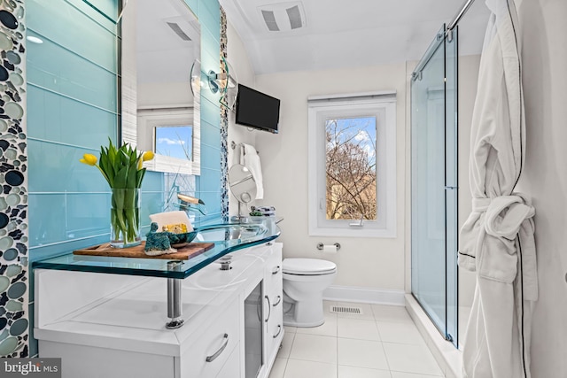 bathroom featuring vanity, tile patterned flooring, toilet, baseboards, and a shower stall