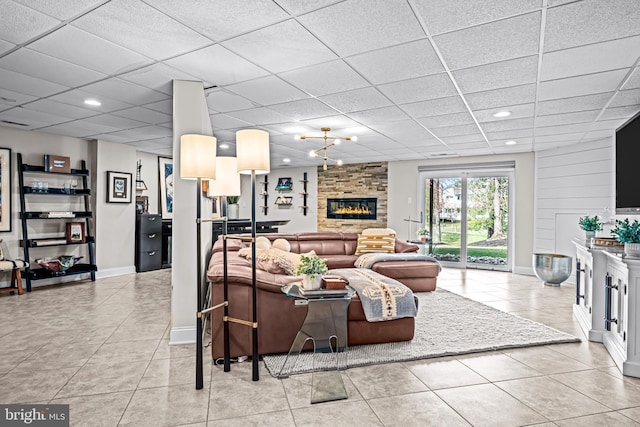 living room featuring light tile patterned floors, baseboards, a drop ceiling, and recessed lighting