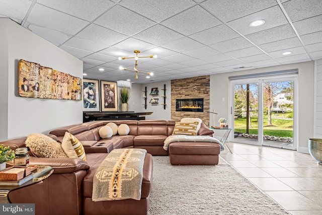 living room featuring tile patterned floors, a drop ceiling, and a large fireplace