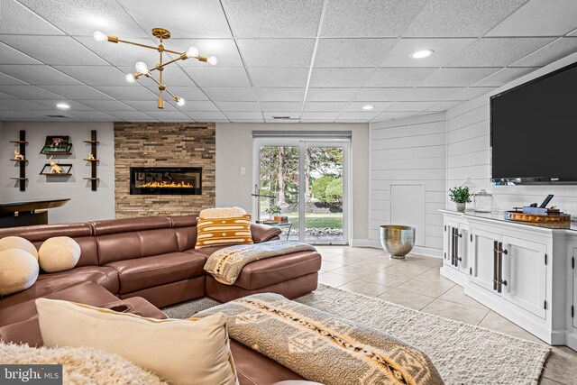 living room featuring recessed lighting, a paneled ceiling, light tile patterned floors, and a fireplace