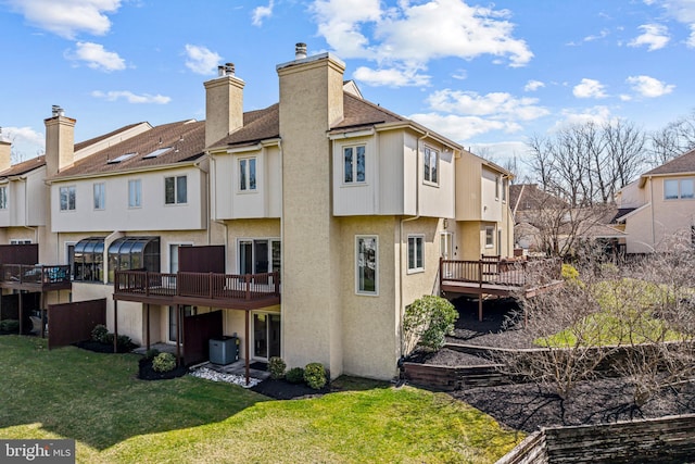 back of house with a residential view, stucco siding, a yard, and a deck