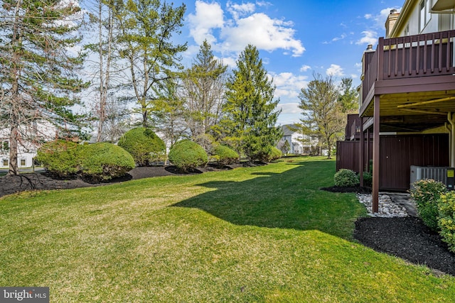 view of yard with central AC unit and a wooden deck