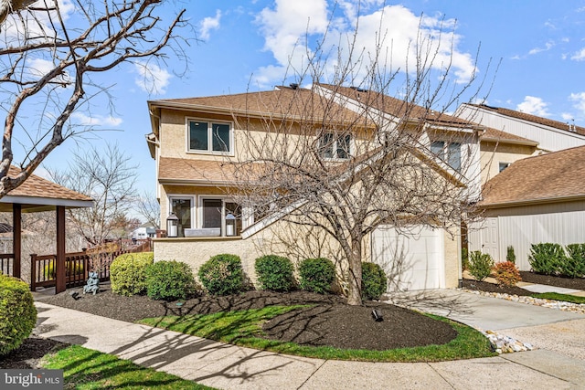 traditional-style home featuring stucco siding and concrete driveway