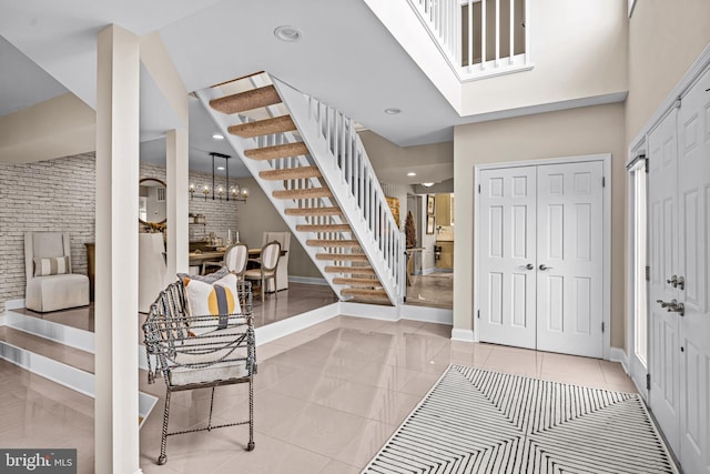 foyer entrance with baseboards, recessed lighting, stairs, and a high ceiling