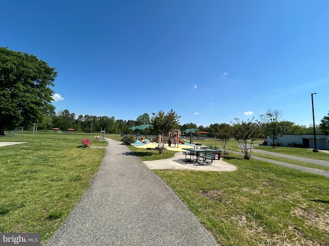 view of property's community featuring a lawn and playground community