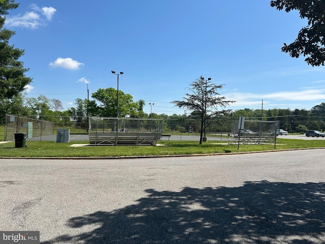 surrounding community featuring a tennis court and fence