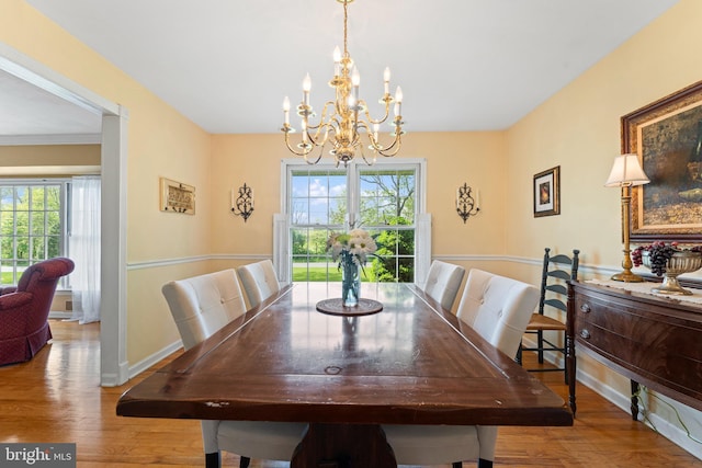 dining room with baseboards, wood finished floors, a chandelier, and a healthy amount of sunlight