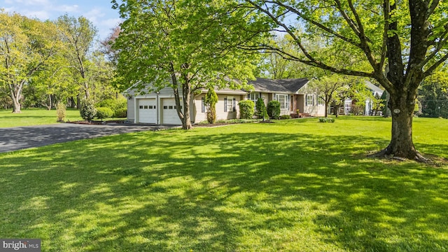 ranch-style home with driveway, a front yard, and a garage
