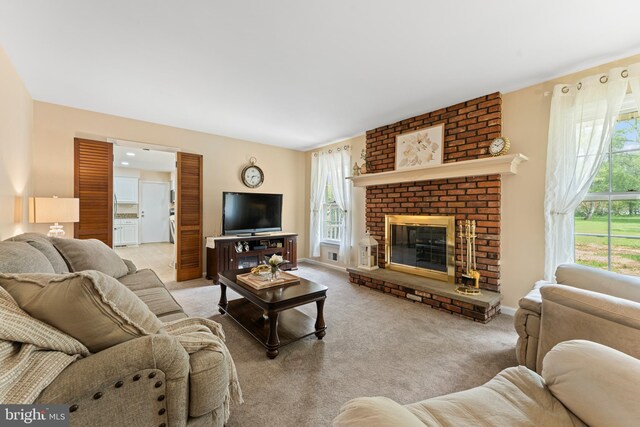living area with a healthy amount of sunlight, baseboards, a fireplace, and carpet flooring