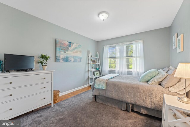 bedroom with baseboards and wood finished floors