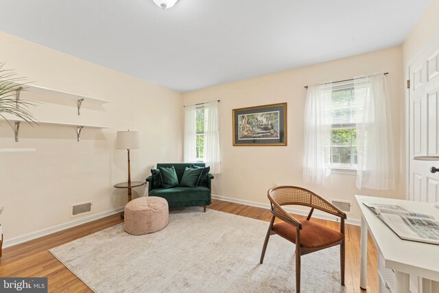 sitting room with baseboards, wood finished floors, and visible vents