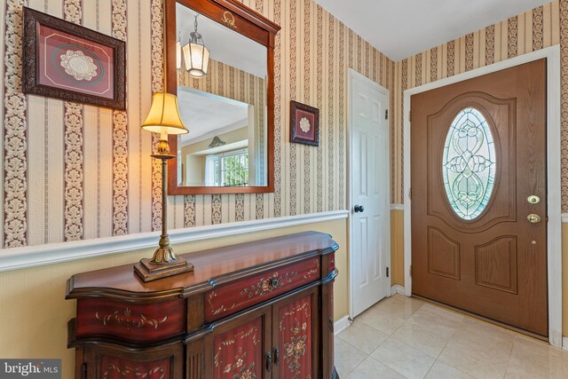 tiled foyer entrance with wallpapered walls