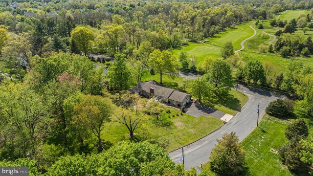 drone / aerial view featuring a view of trees and golf course view