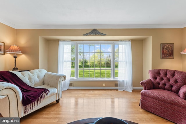 living area with crown molding, baseboards, and wood finished floors