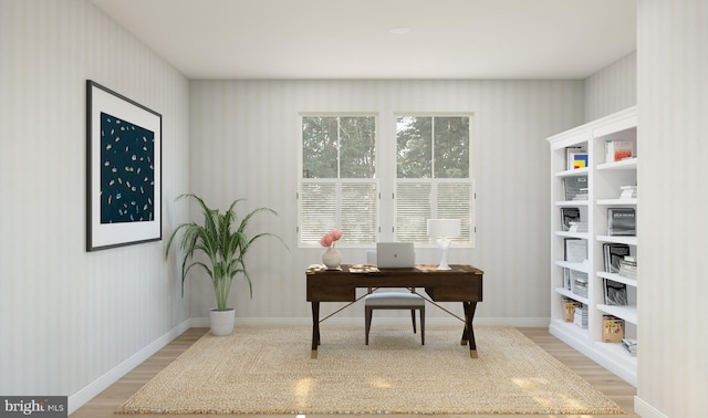 office featuring light wood-style floors, baseboards, and wallpapered walls
