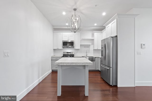kitchen with open shelves, baseboards, light countertops, a sink, and stainless steel appliances