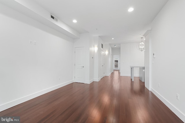 interior space with dark wood-style flooring, visible vents, baseboards, a chandelier, and recessed lighting