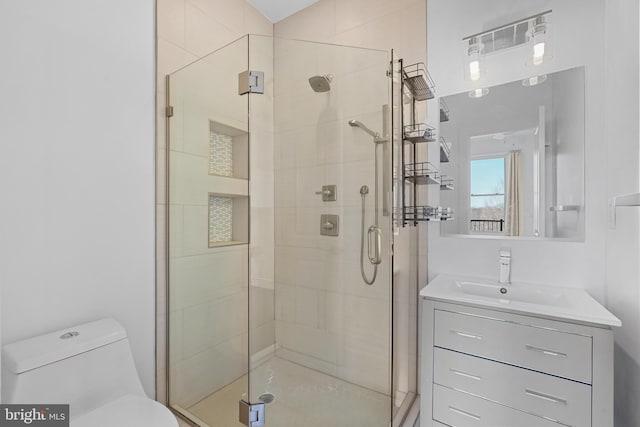 bathroom with vanity, a stall shower, and toilet