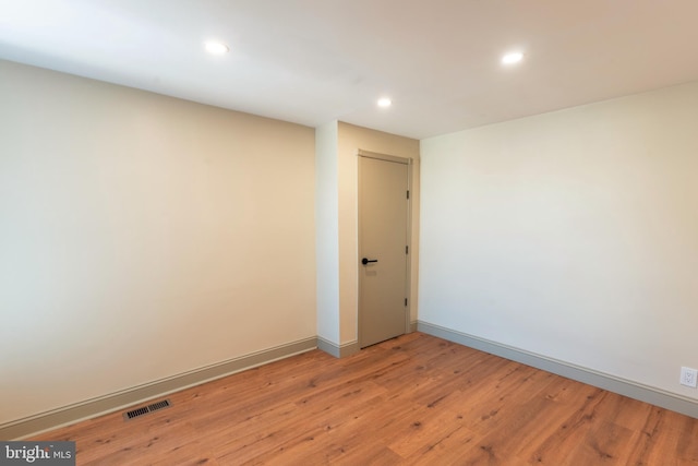 spare room featuring light wood-style floors, baseboards, recessed lighting, and visible vents