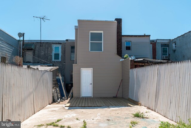 rear view of house featuring a fenced backyard and a wooden deck